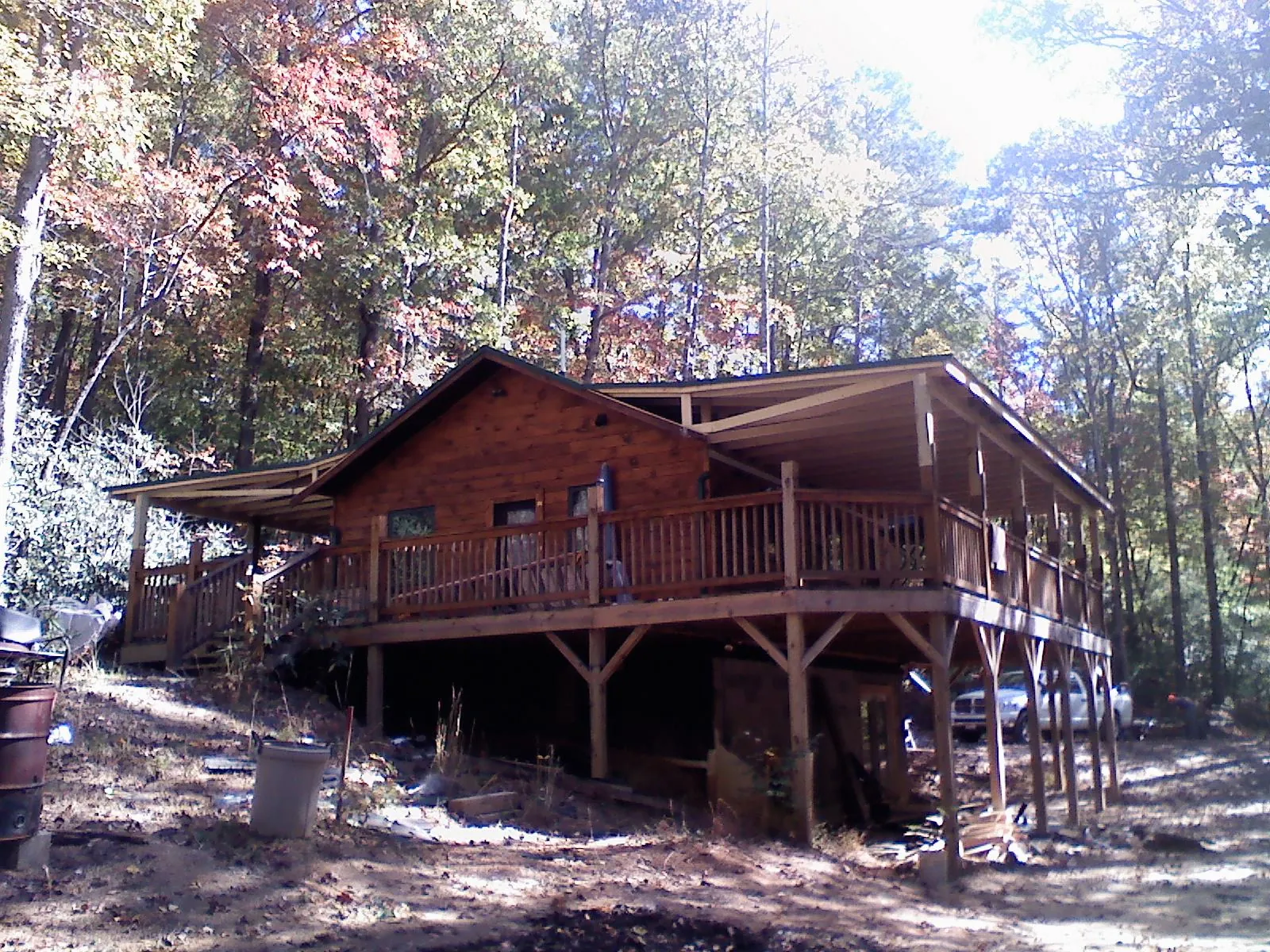 Log cabin with a wraparound porch and metal roof in the fall in Park Valley