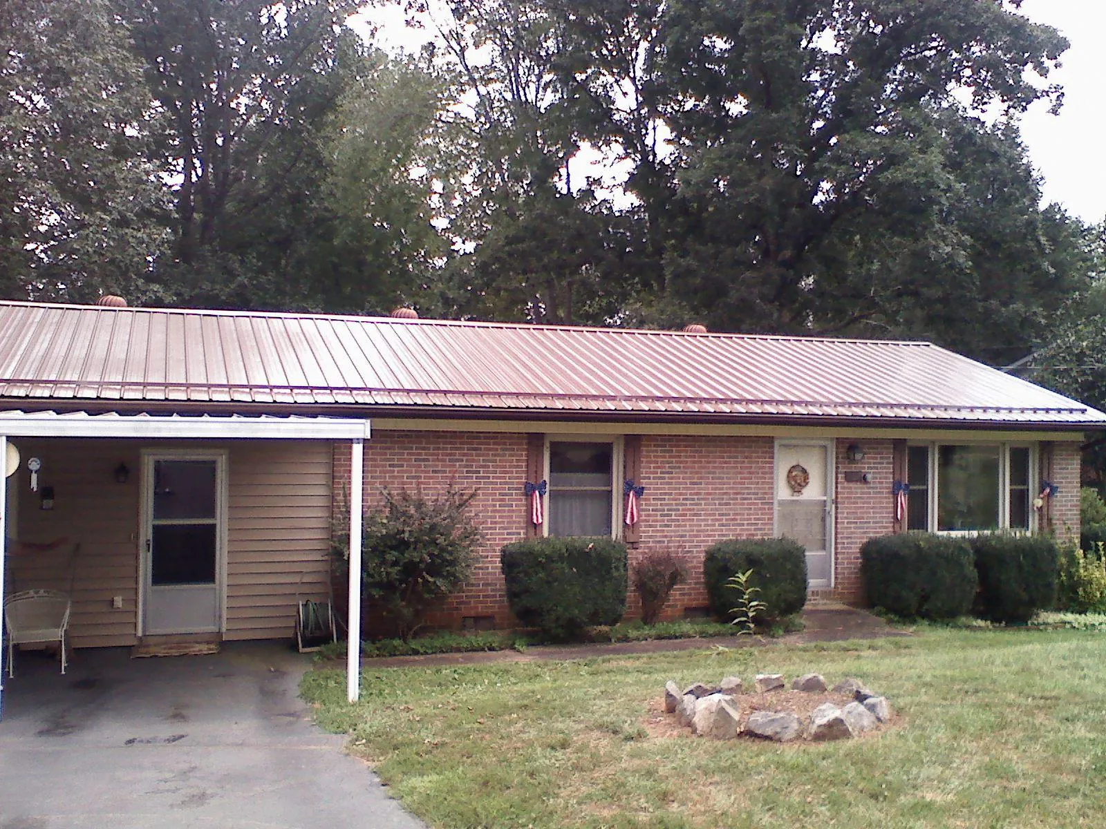 Bronze metal roof and carport on a brick ranch home — Roof Repair work by our crew in Park Valley