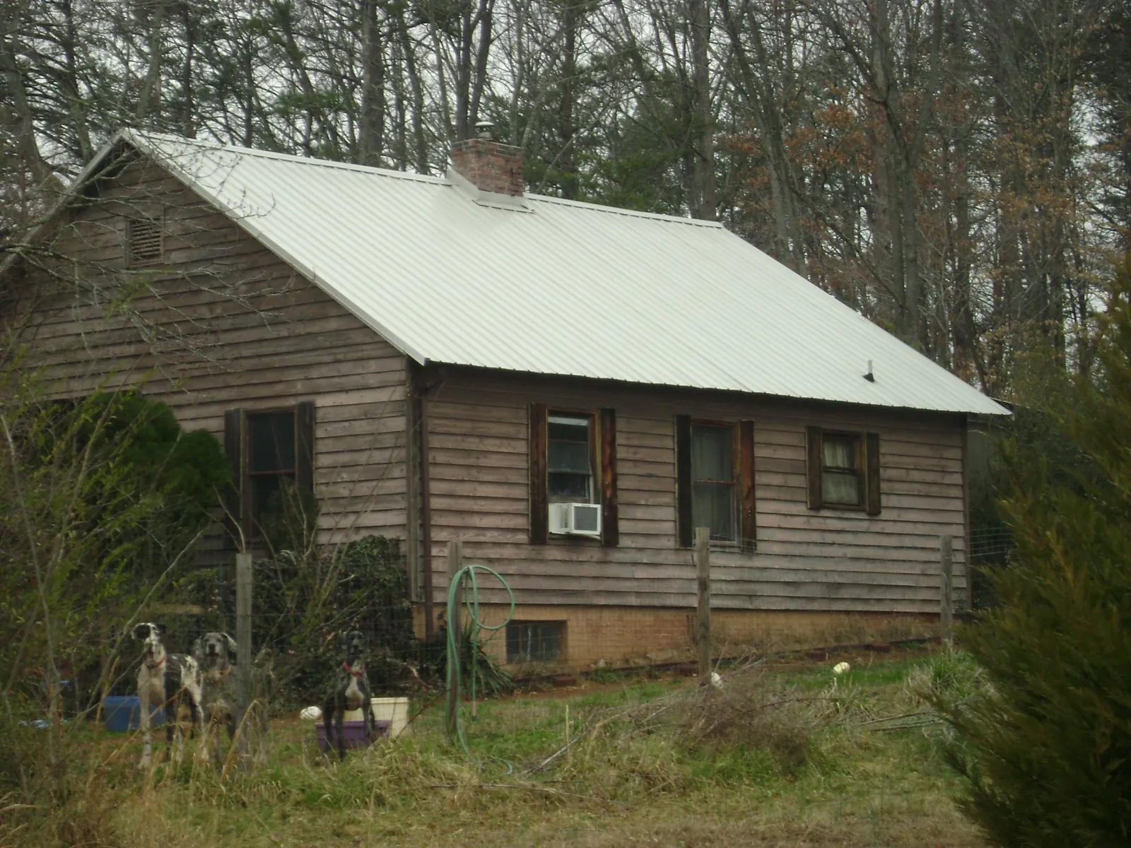 White metal roof on an old wood sided farmhouse, from a Metal Roof Installation job in Park Valley